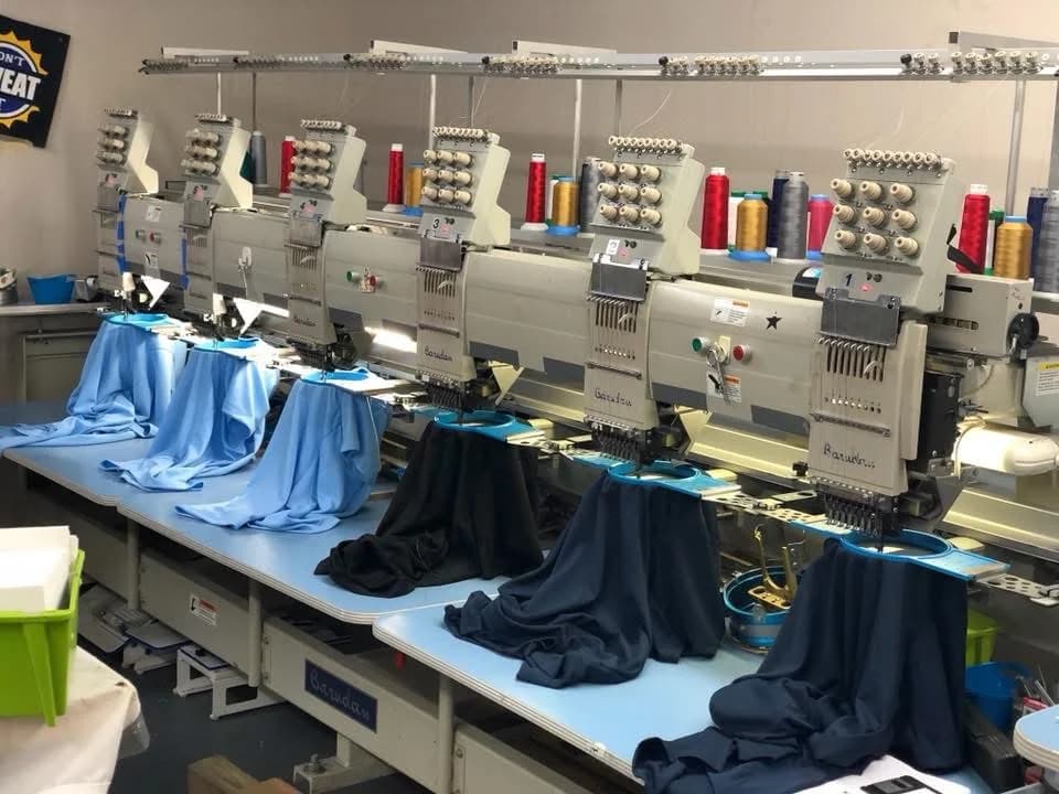 Multi-head commercial embroidery machines running at the Perfect Fitz facility